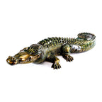 Bronze alligator sculpture on a white background